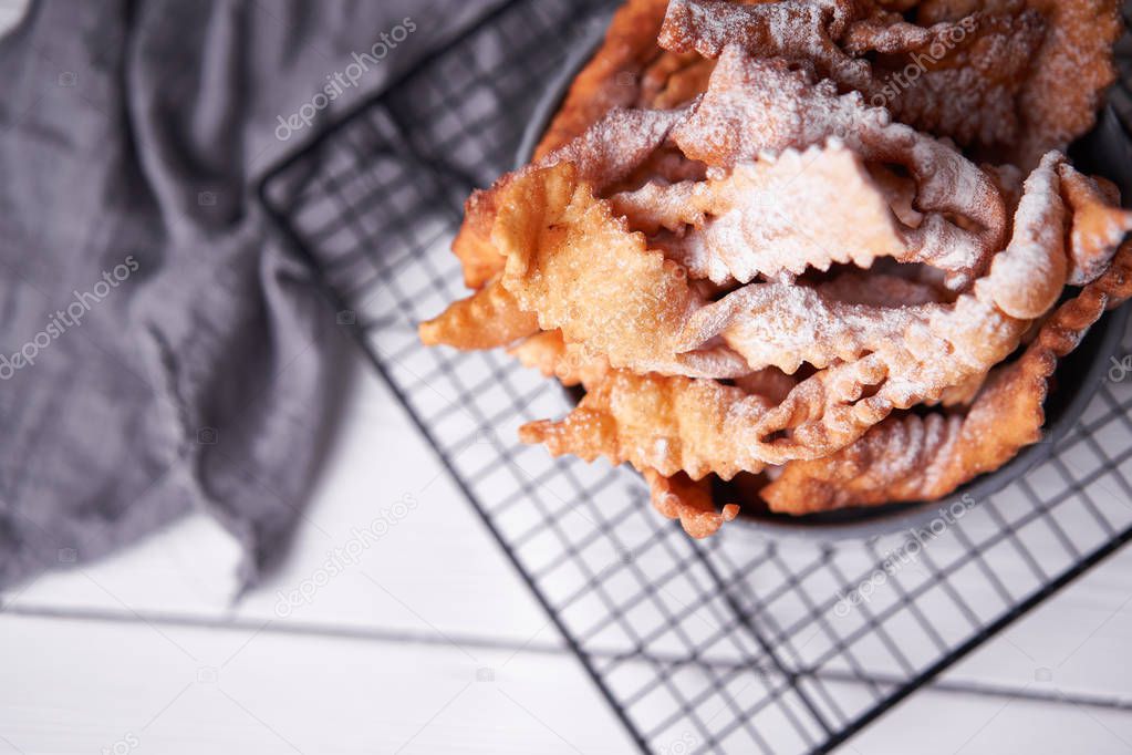 Brushwood - russian traditional cookies with powdered sugar. Food consept. Plate with hvorost on white marble background, Copyspace for text and design elements. Close up top view