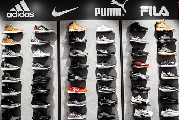 Nurmberg, Tyskland - 27 februari 2019: The Nike, Adidas, Puma och Fila svart man sneakers på shell i butiken. Fashionabla foten bär skor — Stockfoto