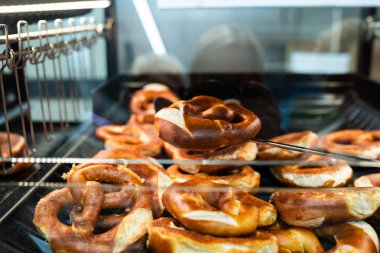 Almanya Ulusal fırını - brezel. Taze simit ekmek raf mağaza. Taze bir Bavyera Brezel bir spatula ile alın. Kahvaltı gıda kavramı