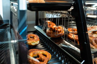 Almanya Ulusal fırını - brezel. Taze simit ekmek raf mağaza. Taze bir Bavyera Brezel bir spatula ile alın. Kahvaltı gıda kavramı