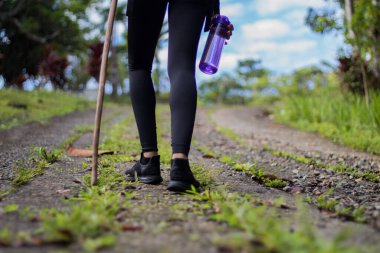 Tepede yürüyen siyah ayakkabılı bacaklar.