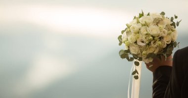 Gelin elinde güzel bir buket gül ve mavi ortanca tutuyor. Düğün günü..