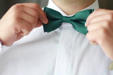Damat elinde papyon tutuyor.