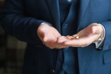 Damadın elinde bir düğün yüzüğü var.