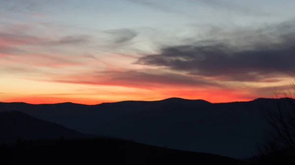 Kızıl gökyüzü gün batımından sonra dağlarda.