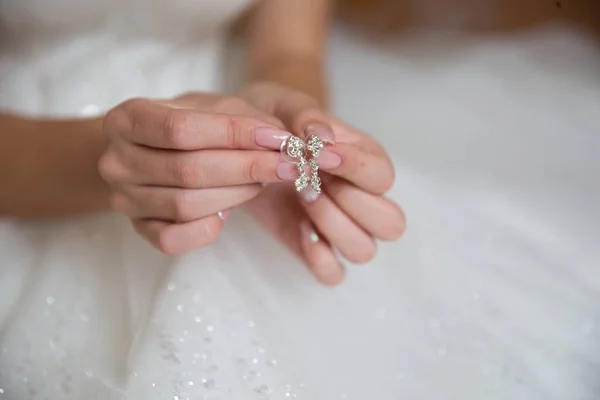 Gelin küpeleri elinde tutuyor.