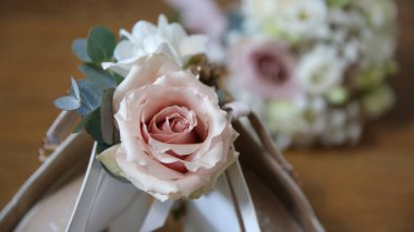 Arka planda gelinin ayakkabılarıyla bir buket çiçek. Düğün günü..