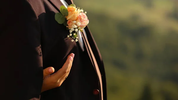 Bir erkeğin ceketinde ve düğününde çiçek