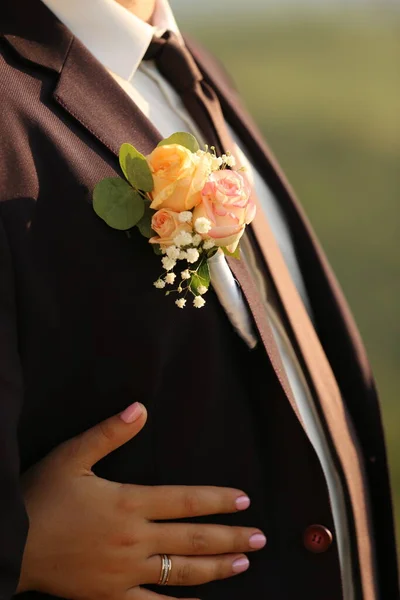 Omzunda çiçek olan ve takım elbiseli bir adam.