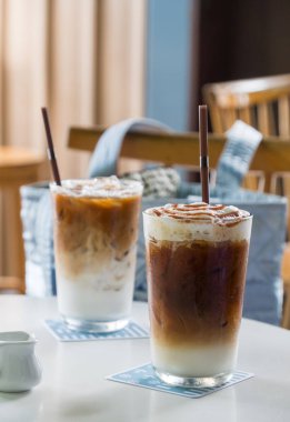 Buzlu karamelli kahve beyaz masada.