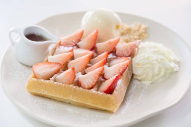 Çilekli waffle ve vanilyalı dondurma.