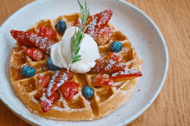 Tahta masadaki karışık böğürtlen waffle 'ının üst görüntüsü