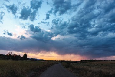 Ovanın ortasındaki yol gün batımında su perdesiyle uzaktaki fırtınanın yönünü gösteriyor. İspanya 'da meteoroloji, turizm, doğa ve seyahatle ilgili