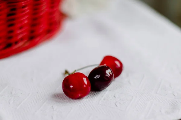 Trois Cerises Deux Rouges Une Noire Sur Fond Blanc Avec — Photo