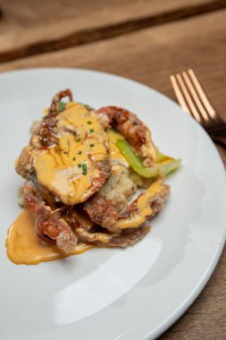 Ahşap bir masada duran kızarmış yengeç.