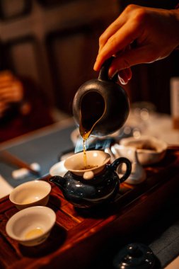 Çin çay seremonisi. Çay, el ve çaydanlığa yakın çekim