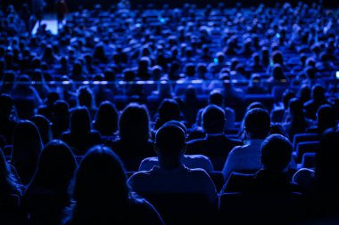 Sinemadaki seyirci, arkadaki manzara. İş konferansında bir grup insan, arka plan, mavi tonlar.