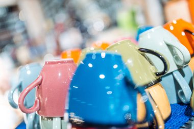 Mutfak eşyaları. Bir restoranın rafında çok renkli boş kupalar var. Farklı odak 