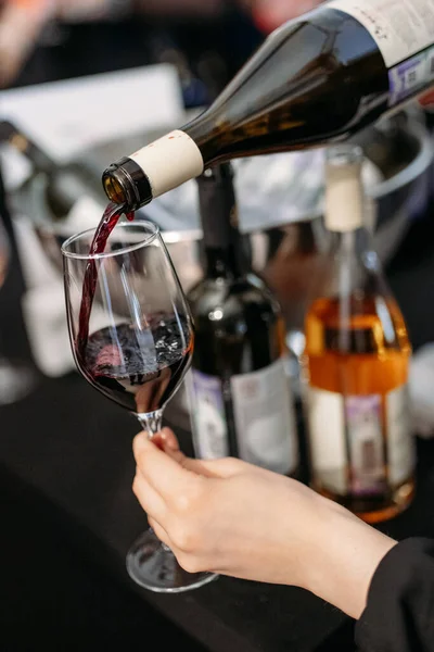 red wine is poured from a bottle into a glass close-up