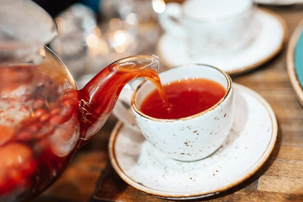 Garson Şeffaf Bir Çaydanlığın Meyveli Çayını Bardağa Doldurur — Stok fotoğraf