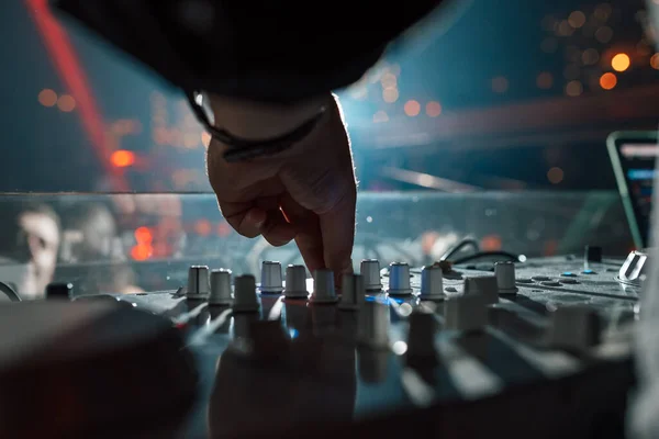 DJ in a nightclub mixing tracks. Hand close-up