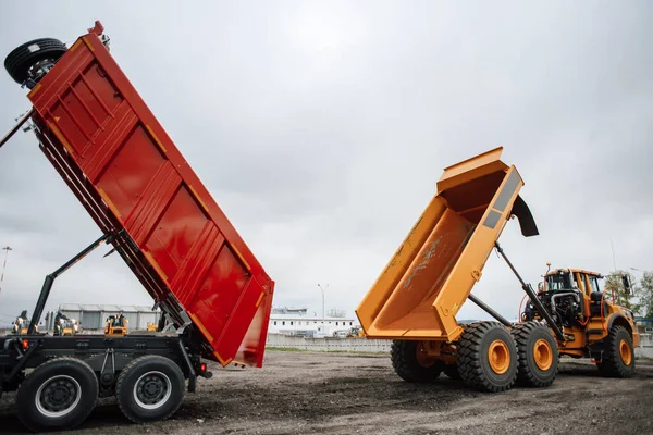 Two construction dump trucks at a special machinery exhibition