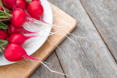 Ahşap kaplamalı taze turp. Yaz, kırmızı turp hasat etti. Boşluğu kopyala.