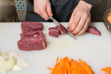 Adım adım ve doğu mutfağının aşamaları - pilav. Aşçı pilav için bir parça et keser.