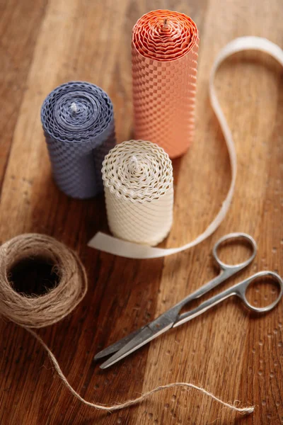 Dekoratif mumlar, makas ve sicim ahşap masada.