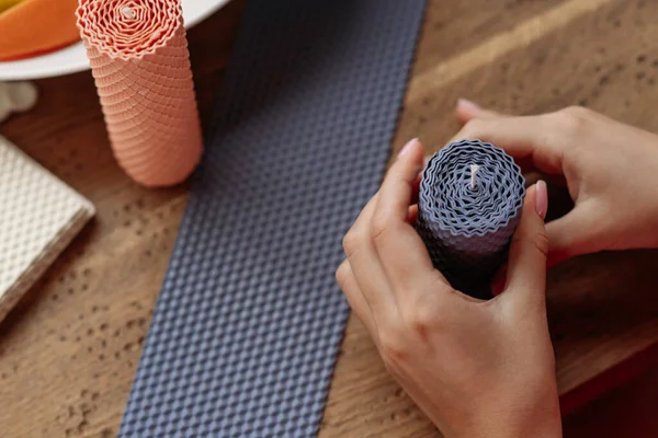 DIY wax candle making process. Woman making decorative wax candle, close-up of hands