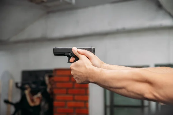 Shooting range. Rear view of men shooting with gun in shooting range