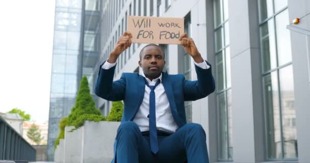 Potret pemuda Afrika-Amerika yang mendemonstrasikan poster dengan kata-kata akan bekerja untuk makanan. Aktivis pria menunjukkan papan dengan mencari pekerjaan pengumuman. Kesepian memprotes. Setelah pengangguran dikunci — Stok Video