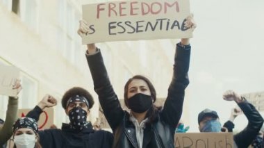 Irkçılığı ve insan haklarını protesto eden insanlar arasında Özgürlük posterini tutan maskeli güzel beyaz bir kadın şarttır. Eşitlik için dışavurum.