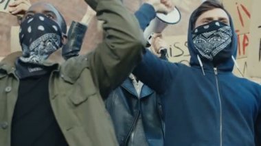 Irkçılık ve şiddete karşı düzenlenen gösteride kadın ve erkek protestocular bağırıyor ve sloganlar atıyorlar. Sokak grevindeki çok ırklı öğrenciler. Etkin toplum.