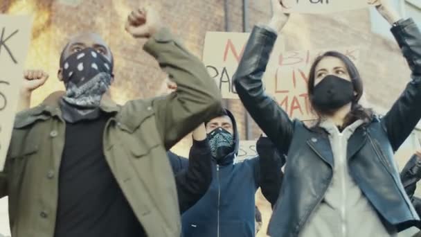 Mannelijke en vrouwelijke jonge multi-etnische studenten protesteren en schreeuwen slogans voor zwarte mensen waardigheid en gelijkheid. Manifestatie voor de rechten van Afro-Amerikanen. Demonstratie voor democratie op straat. — Stockvideo