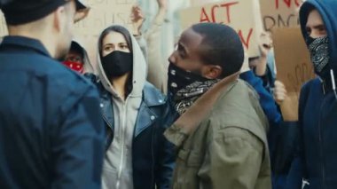 Genç Afrikalı Amerikalı protestocu insan hakları gösterisinde polise bağırıyor ve bağırıyordu. ABD 'li protestocular polis şiddetini protesto etmek için polisle kavga ediyor ve kavga ediyorlar.