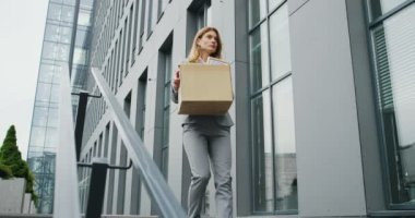 Depresyondaki beyaz kadın ofis çalışanı iş merkezinden kişisel eşyalarla birlikte ayrılıyor. İş kadını işini kaybetti. Kovulan kadın dışarıda yürüyor. Depresyondaki işsiz kişi işsizlik kavramı