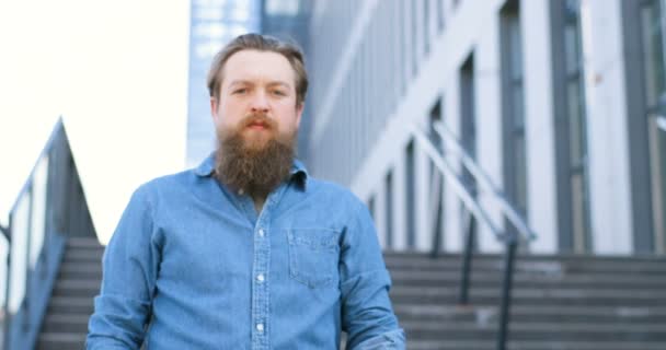 Ritratto di giovane uomo caucasico bello con barba e camicia blu jeans in piedi alle scale all'aperto. Maschio attivista manifesto aumento con la parola Sì e dimostrando alla macchina fotografica . — Video Stock