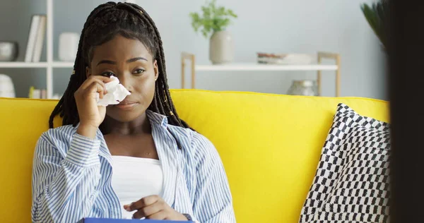 Çekici Afrikalı Amerikalı genç bir kadın evdeki sarı kanepede dinleniyor ve hüzünlü film yüzünden ağlayıp televizyon seyrediyor. Kapalı