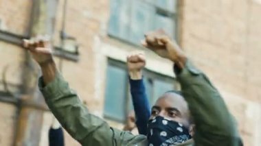 Irkçılık ve polis şiddetini protesto eden maskeli kadın ve erkek protestocular. Melez ırk isyancıları ve ABD 'de sloganlar atan posterler. Siyasi eylemciler.