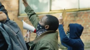 Polis ve hükümete karşı sokak ayaklanmasında Afrikalı Amerikalı erkek protestocuların bağırışları ve bağırışları. Karma ırk protestocularının ve isyancıların arkası..