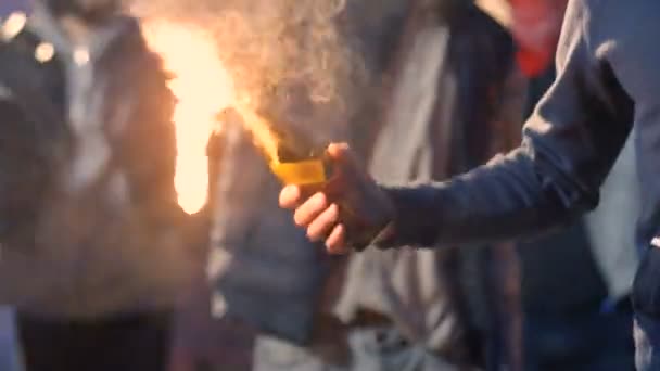 Jonge blanke man met masker op gezicht die Molotov cocktail vasthoudt en gooit terwijl hij protesteert in rommelige menigte. Mannelijke demonstrant lanceert vuurfles bij straatrellen. Agressieve manifestatie. — Stockvideo