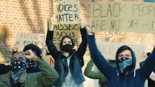 Çok ırklı erkek ve kadın protestocular ırkçılığı ve polis şiddetini protesto ediyorlar. Gösteride insanların sloganlarını haykıran posterlerle karışık ırklar. Eşit insan hakları kavramı — Stok video