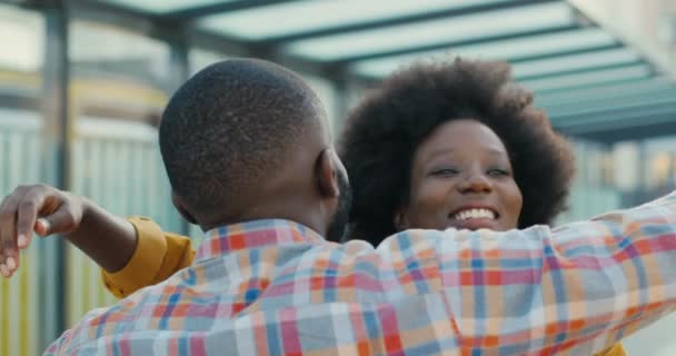 Zadní část Afroameričan mladý muž setkat se svou přítelkyní nebo přítelem a objímání na ulici. Zavřít. Zadní pohled na chlapa objímajícího holku. Šťastná žena utíká a potkává přítele v objetí. Vztahy. — Stock video