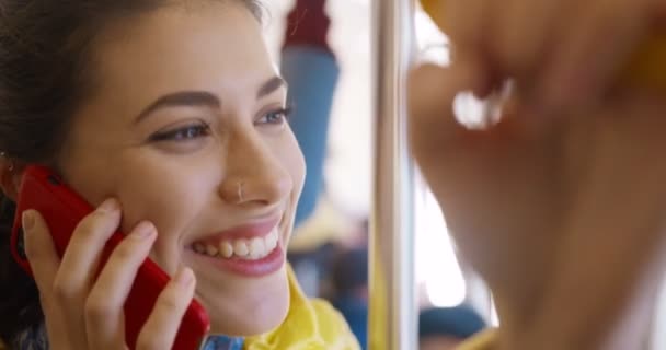 Close up of happy cheerful young Caucasian pretty girl standing in bus and talking on cellphone. Joyful female passanger of public transport speaking on phone. Smiled woman having call in tram. — Stock Video