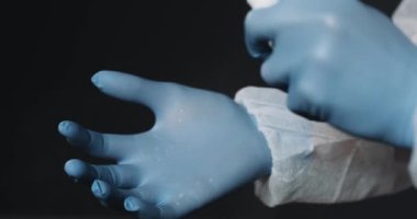 Doktorun mavi lastik eldivenleriyle ellerini kapat. Elinde dezenfektan püskürtüp yayılıyor. Temizlik konsepti. Bakteriler öldürülüyor.