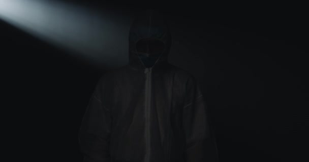 Портретный снимок кавказского медика-эпидемиолога в полной защите с медицинской маской и очками, скрещивающимися руками и смотрящими в камеру с уставшими глазами на черном фоне. Эпидемия Ковида - 19 . — стоковое видео