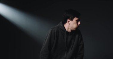 Beyaz, genç, yakışıklı, sağlıksız bir adam. Kaba ve hapşırıyor. Yüzü kolları ve dirseğiyle kaplanmış. Covid-19 semptomları. Grip veya soğuk algınlığı olan erkek hasta.