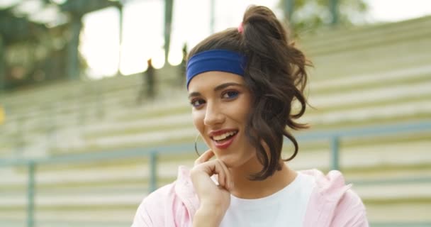 Primo piano di allegra bella ragazza caucasica vintage chewing gum e sorridente alla fotocamera sulla strada. Bella gioiosa femmina stile retrò di buon umore guardando la fotocamera all'aperto. Concetto ritratto — Video Stock