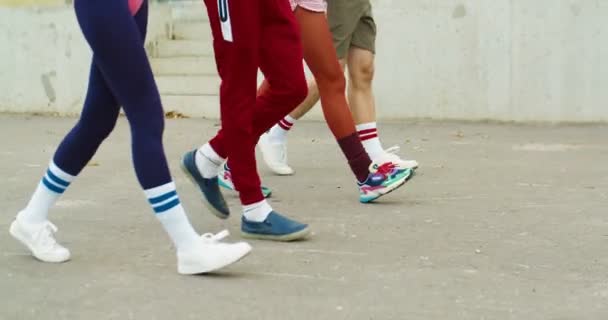 Веселые кавказские винтажные спортсмены и спортсменки, занимающиеся ходьбой по улице. Радостные мужчины и девушка в ретро стиле одежды ходить на открытом воздухе. Групповые тренировки. Спортивный образ жизни. Концепция 70-х — стоковое видео